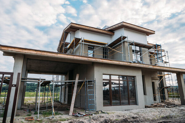 building construction with scaffolding under cloudy sky