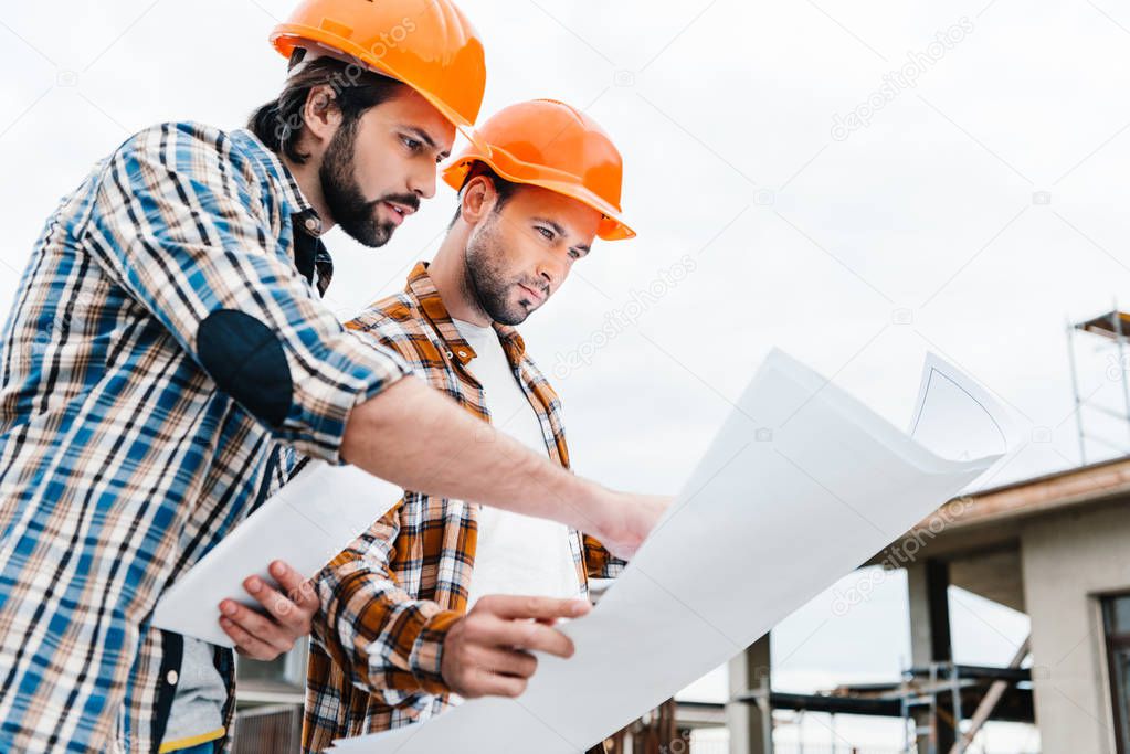 confident architects working together with construction plan