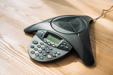 Ofis ahşap masa üzerinde konferans telefon yakın çekim vurdu