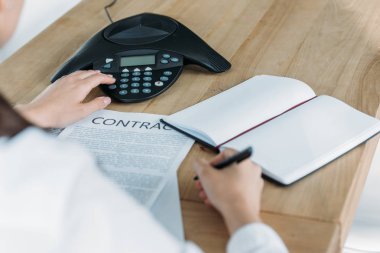 konferans telefon ofisinde masada düğmeye sözleşme ile iş kadını kadeh kırpılmış