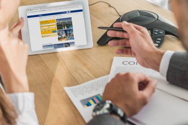 işadamı ve tablet, rezervasyon web sitesinde ekran bakarak işkadını kırpılmış