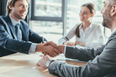 business people shaking hands during meeting at modern office clipart