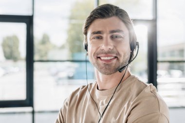close-up portrait of smiling young support hotline worker with headphones clipart