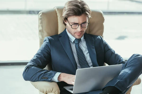 Handsome Focused Businessman Sitting Armchair Using Laptop — Free Stock Photo