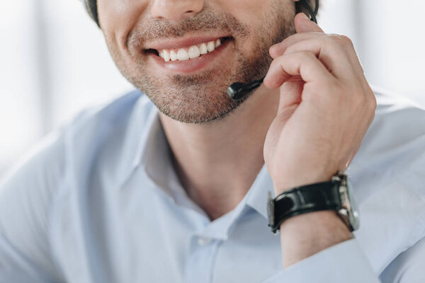 cropped shot of smiling support hotline worker holding microphone