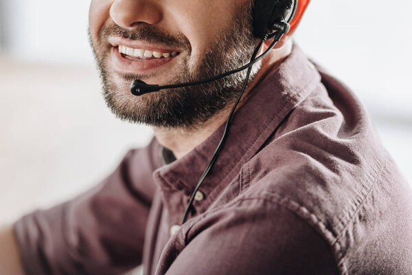 cropped shot of smiling call center worker with microphone