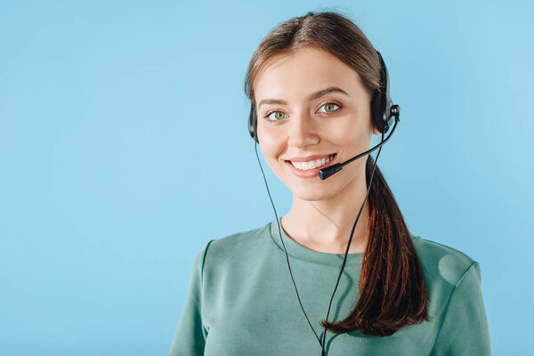 attractive smiling female call center worker looking at camera isolated on blue