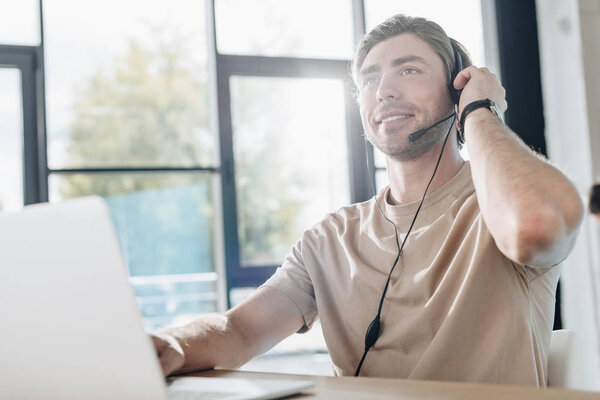 handsome young call center worker working at modern office