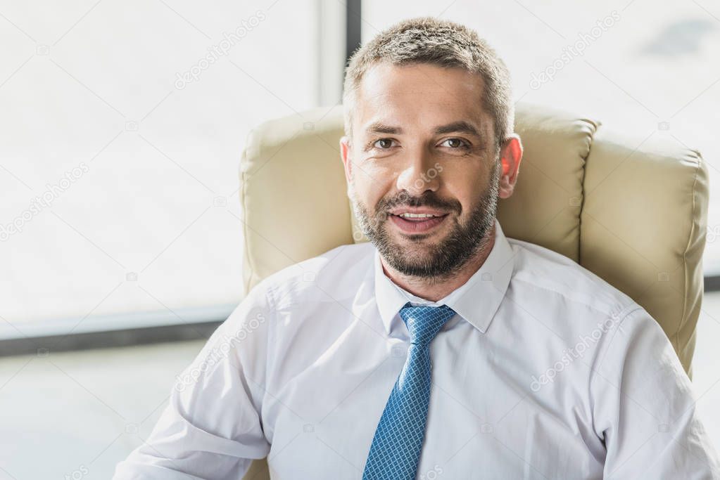 close-up portrait of handsome smiling businessman looking at camera