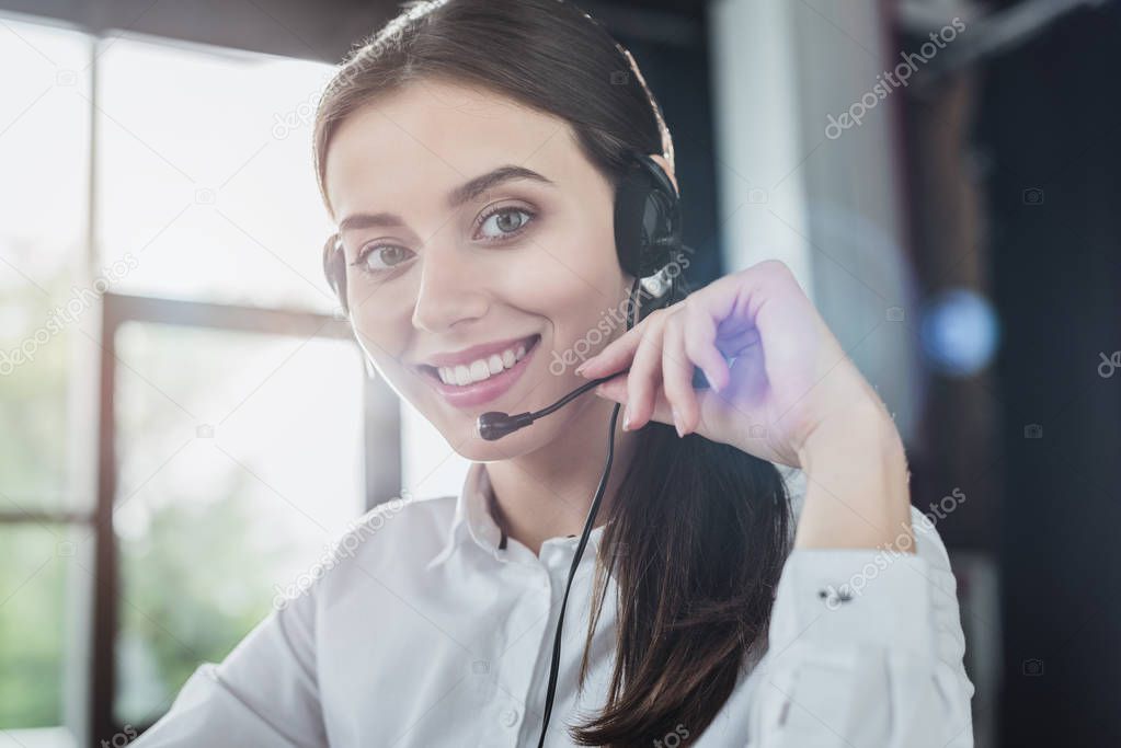 beautiful female call center worker with headphones looking at camera