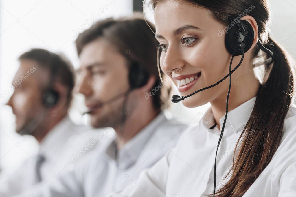 smiling young call center manageress working with colleagues