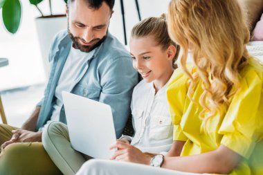 Mutlu genç ailesi dizüstü birlikte evde kullanma