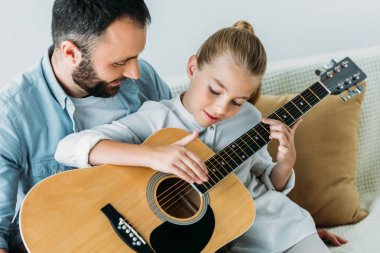 Baba ve kızı evde birlikte gitar