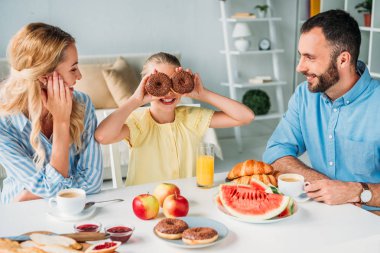 kızları donuts gözlerle kapsayan bakarak mutlu anne