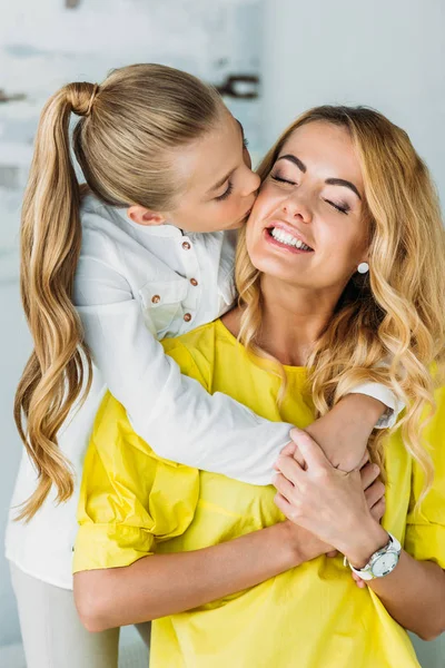 Entzückende Kleine Tochter Umarmt Mutter Von Hinten Und Küsst Sie — Stockfoto