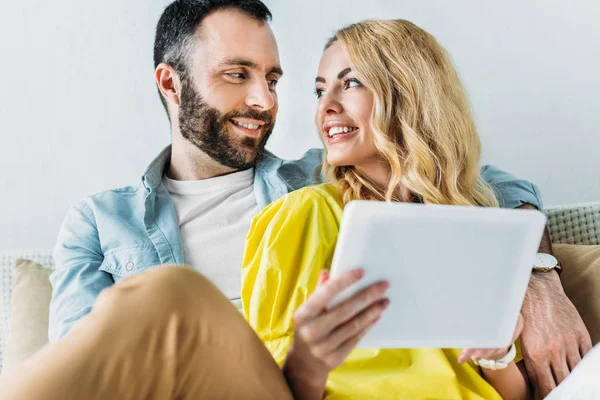 Šťastný Pár Společně Pomocí Tabletu Zatímco Sedí Gauči Doma — Stock fotografie