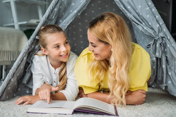 母亲和女儿躺在帐篷 在家看书 — 图库照片