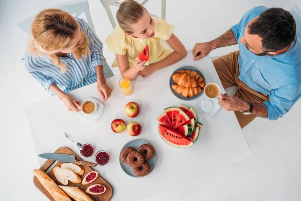 top view of beautiful young family having breakfast together