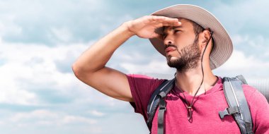 handsome male traveler in hat looking away clipart