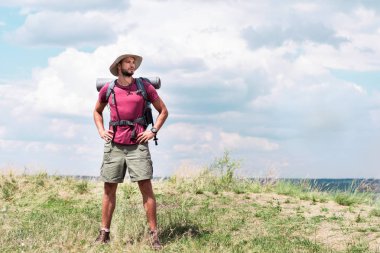 Gezgin yaz çayır ayakta sırt çantası ve turist mat ile