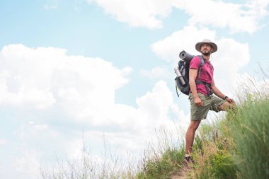 male hiker in hat with backpack and tourist mat clipart