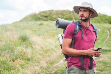 yaz çayır on smartphone kullanarak sırt çantası ile erkek turist