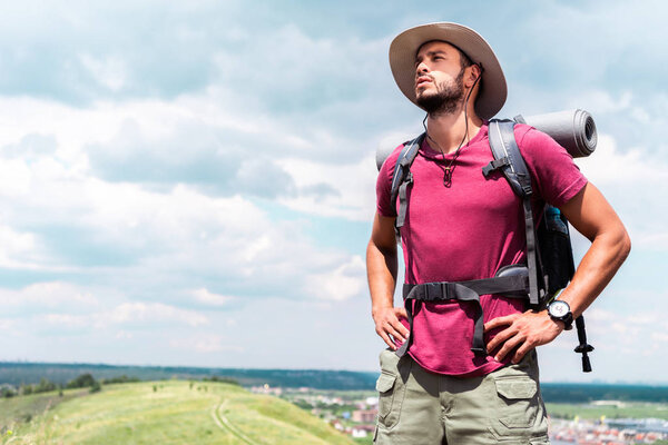 handsome hiker in hat with backpack and tourist mat