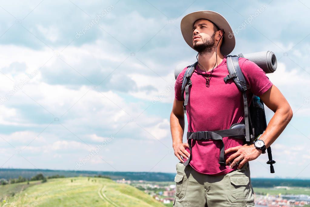 handsome hiker in hat with backpack and tourist mat