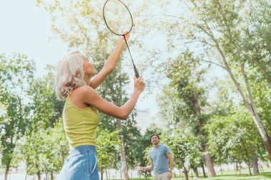 couple playing badminton outdoors in summer clipart