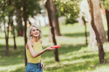 beautiful girl throwing frisbee disk in park  clipart