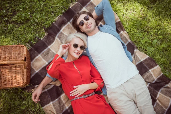 Visão Alto Ângulo Casal Óculos Sol Deitados Juntos Cobertor Parque — Fotografia de Stock