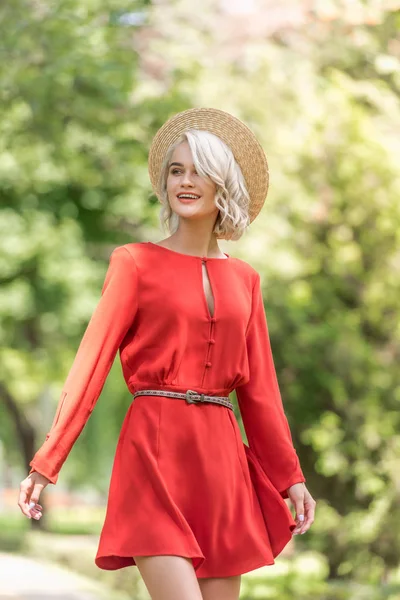 Zâmbind Fată Atractivă Rochie Roșie Pălărie Paie Uitându Parc — Fotografie, imagine de stoc