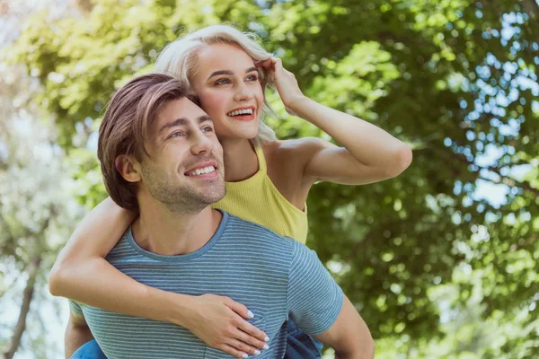 Přítel Dává Piggyback Přítelkyni Parku Koukal — Stock fotografie