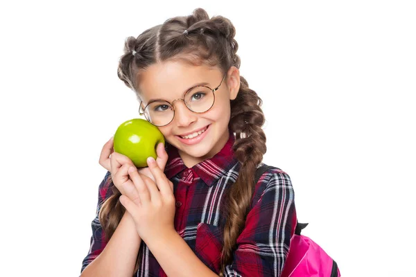熟したリンゴを押しながら白で隔離カメラ目線かわいい小学生 — ストック写真