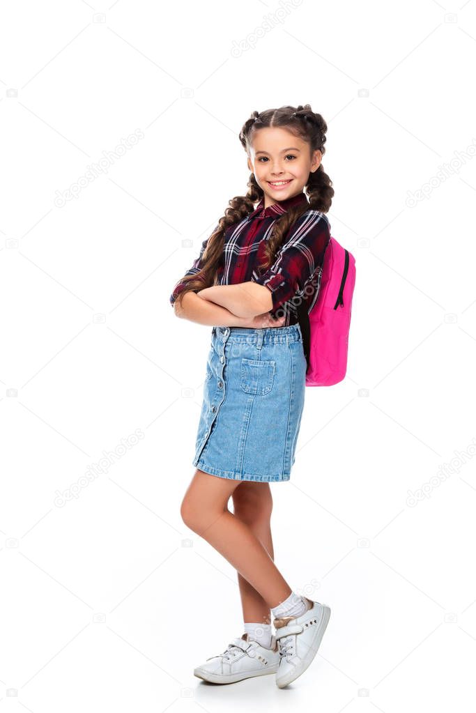 schoolchild with pink backpack standing with crossed arms isolated on white