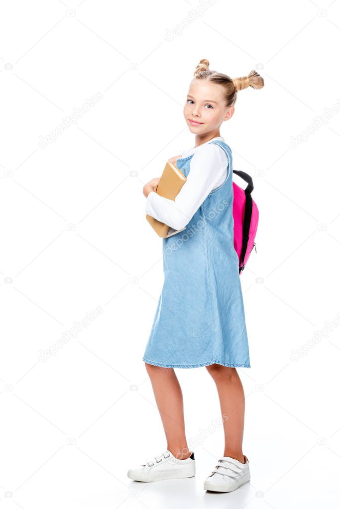 adorable schoolchild with pink backpack holding books and looking at camera isolated on white