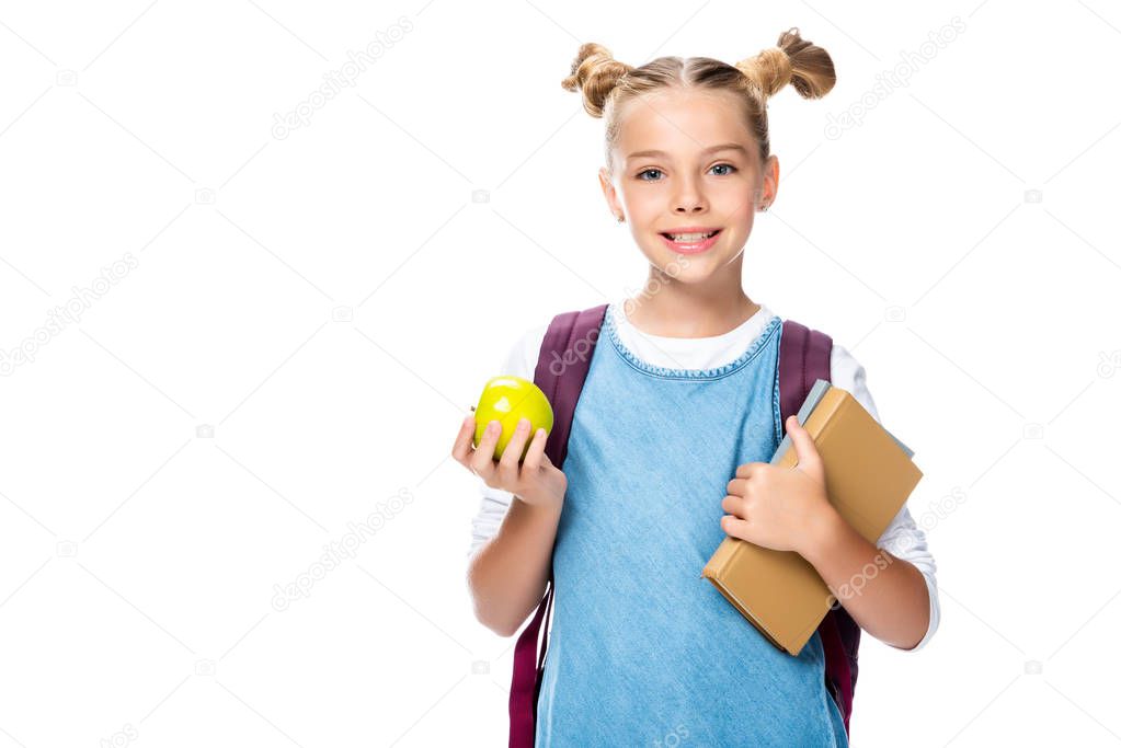 smiling schoolchild holding apple and books isolated on white