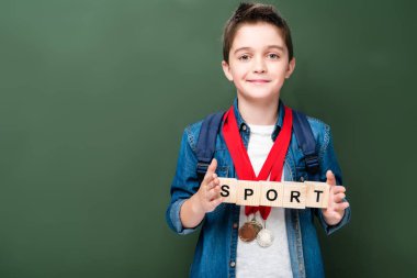 ahşap küpleri ile kelime spor blackboard yakın tutarak madalya ile öğrenci
