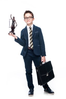 schoolboy in costume of lawyer holding themis statue and bag isolated on white