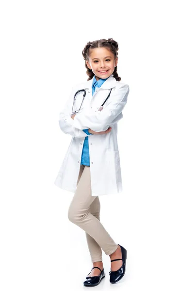 交差した腕を白で隔離突っ立っている医者の衣装で小学生の笑顔 — ストック写真