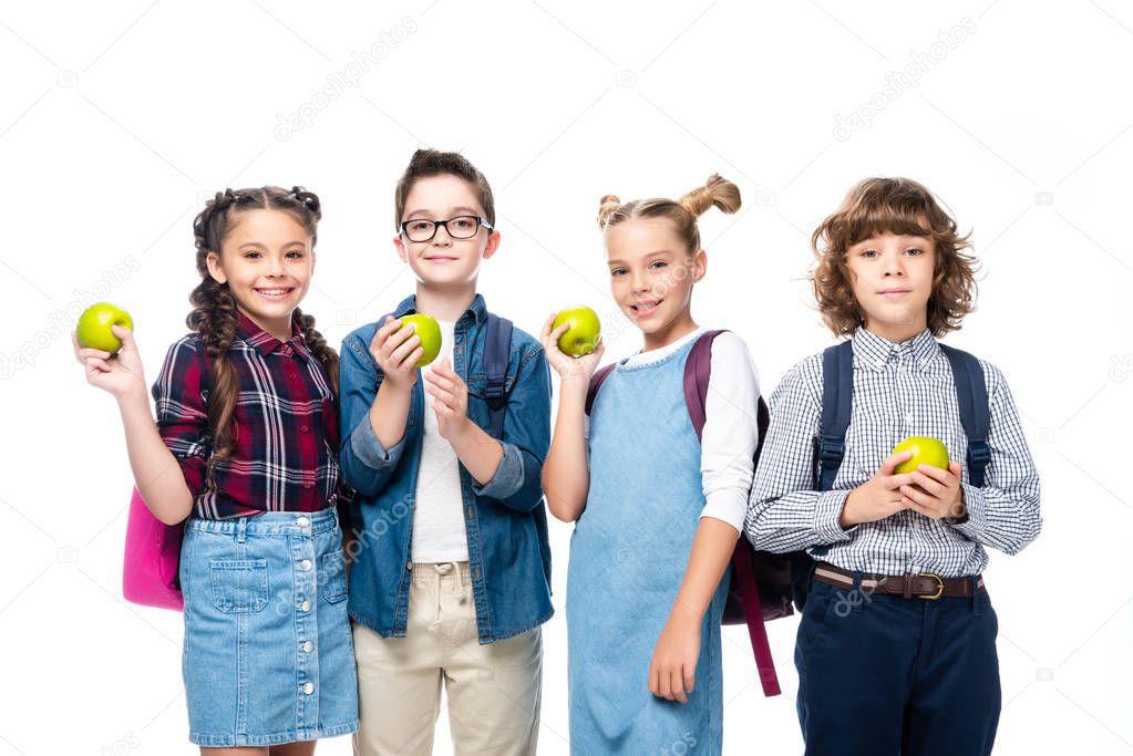 smiling schoolchildren holding ripe apples isolated on white