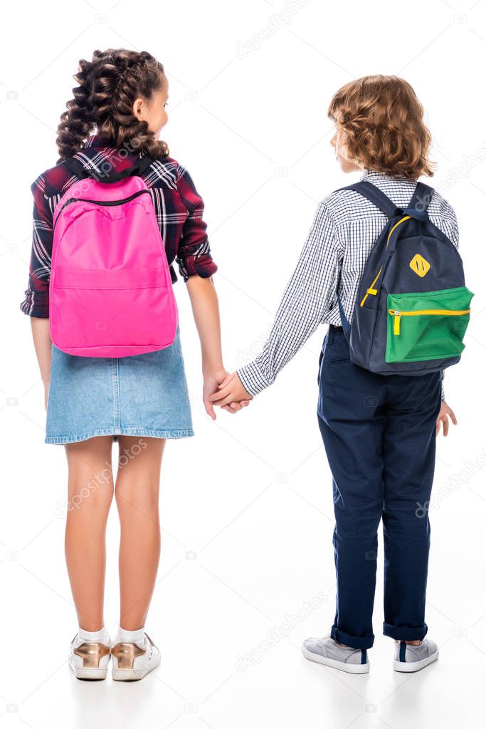 back view of classmates with backpacks holding hands isolated on white