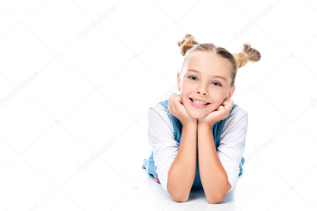 schoolchild lying and resting chin on hands isolated on white