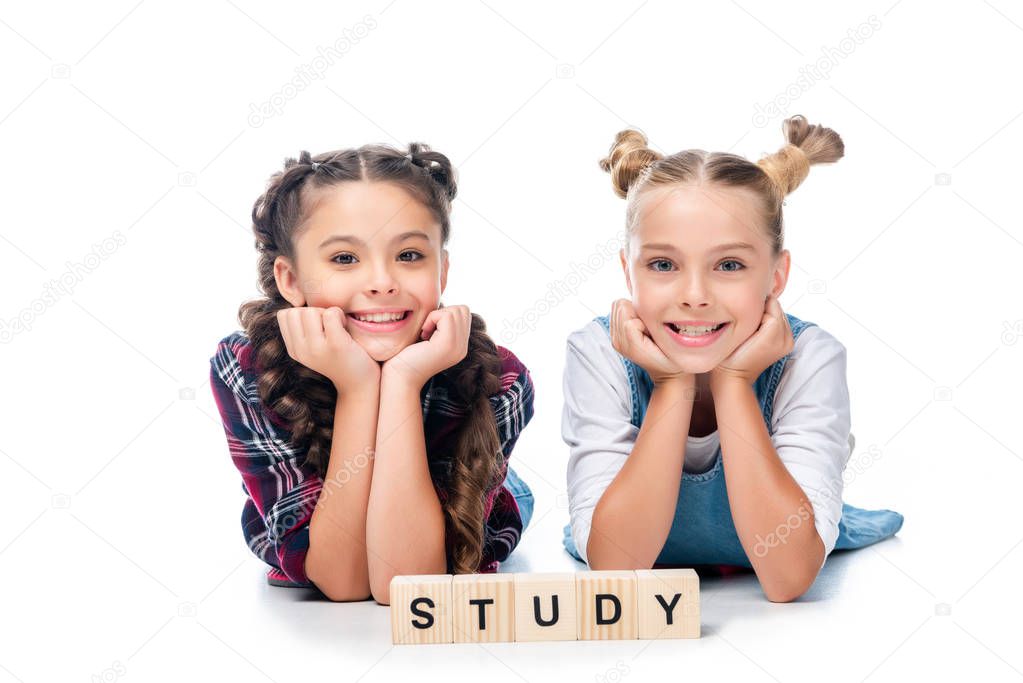 schoolchildren lying near wooden cubes with word study isolated on white 