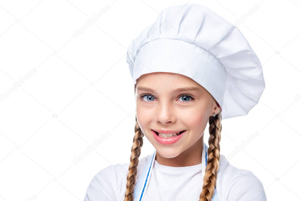 portrait of schoolchild in chef hat looking at camera isolated on white