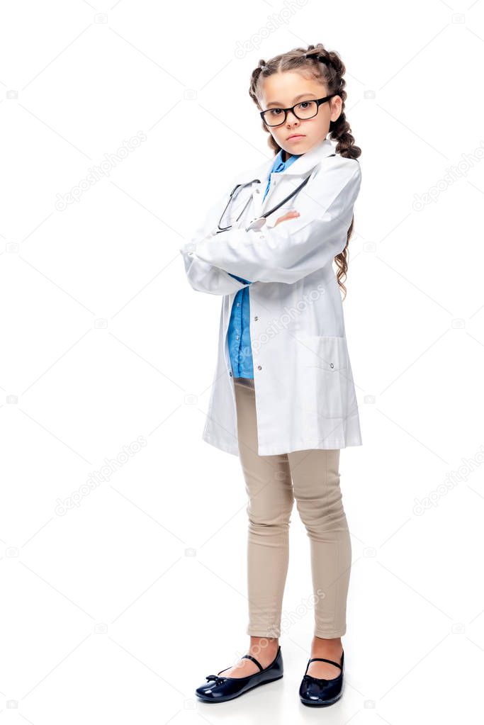 serious schoolchild in white coat standing with crossed arms isolated on white