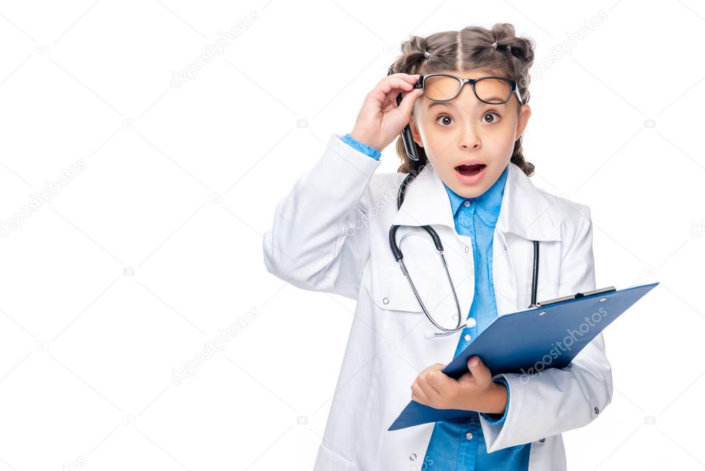 shocked schoolchild in costume of doctor holding clipboard isolated on white