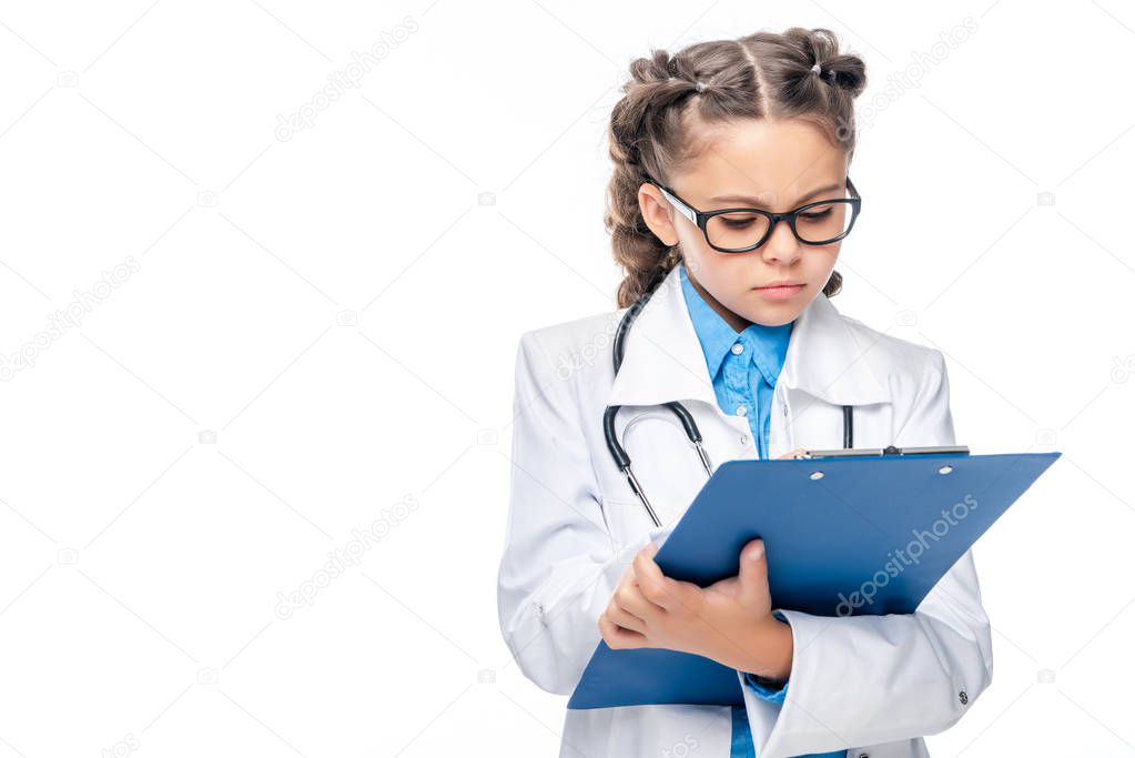 schoolchild in costume of doctor writing something to clipboard isolated on white