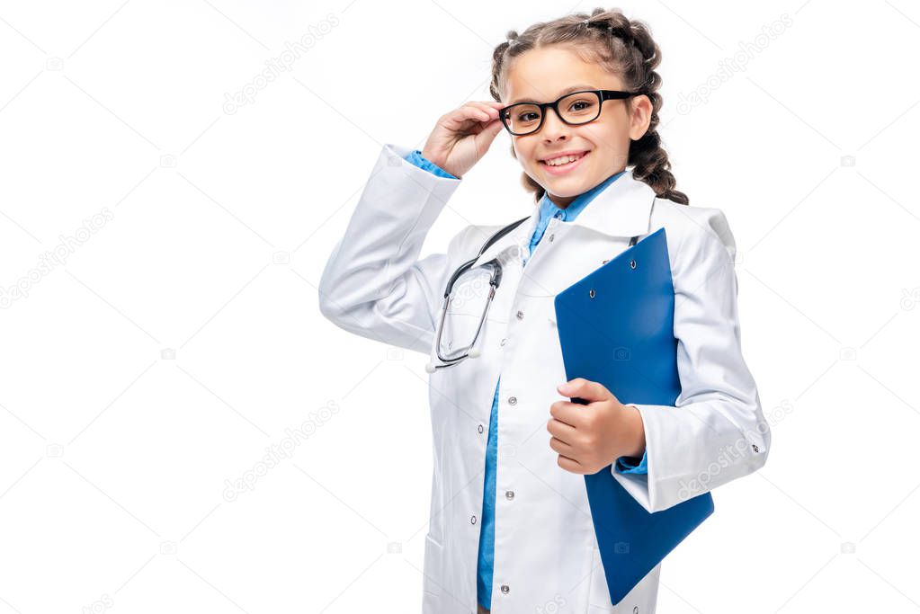 schoolchild in costume of doctor holding clipboard isolated on white