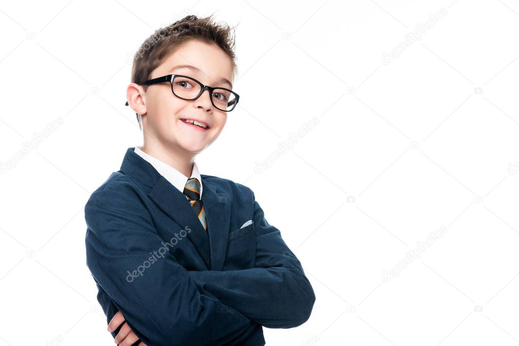 smiling schoolboy in businessman suit looking at camera isolated on white